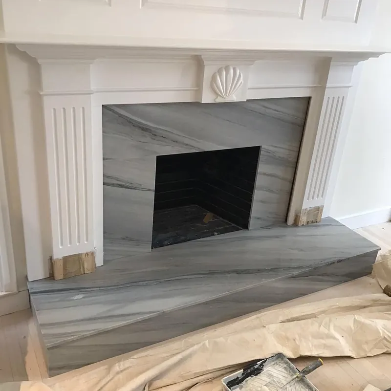 Fireplace surround and hearth in Alexander Blue marble inside a white mantel, Osterville, MA
