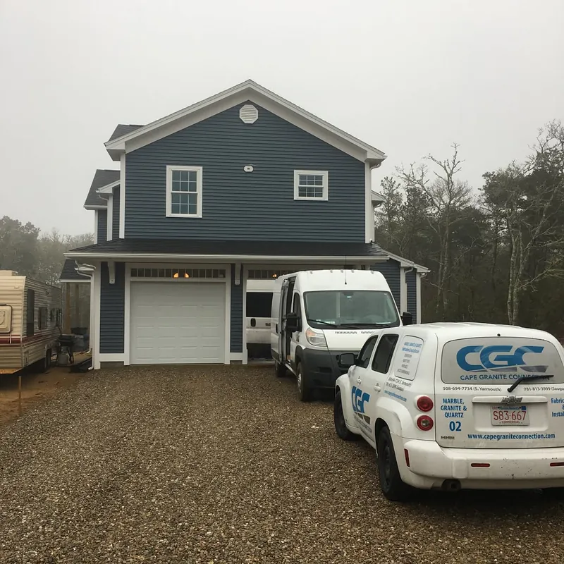 Cape Granite Connection vans parked at a job site in Harwich, MA